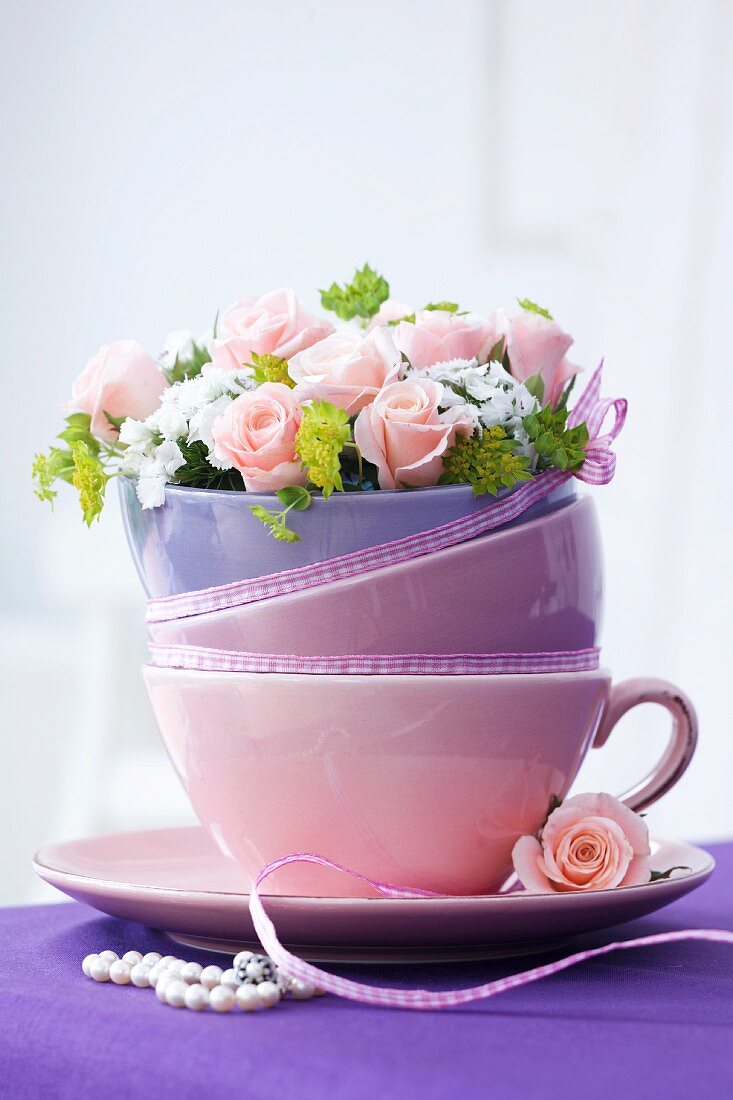 Gestapelte Tasse und Schalen mit Rosengestck