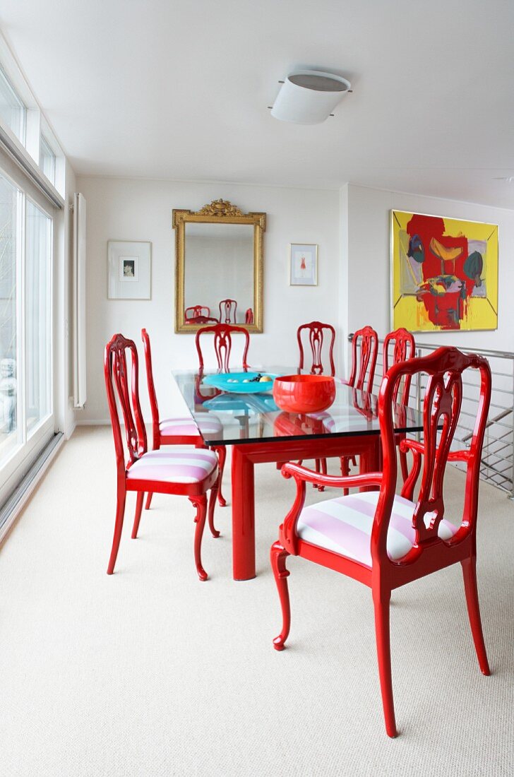 Esszimmer mit roten Stühlen und einem Glastisch