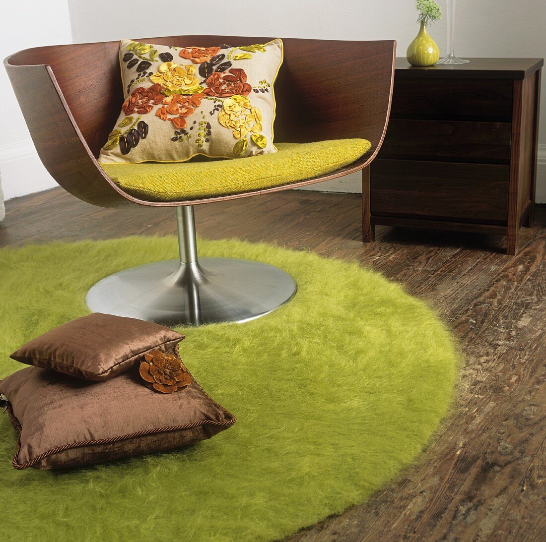 Holzdrehstuhl mit Kissen auf einem runden grünen Teppich