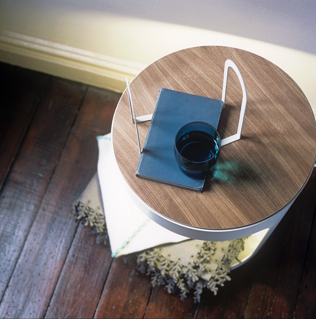 Blick auf einen runden Tisch mit Buch und Glas
