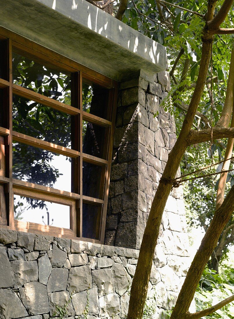 Natursteinfassade eines Wohnhauses mit modernem Sprossenfenster