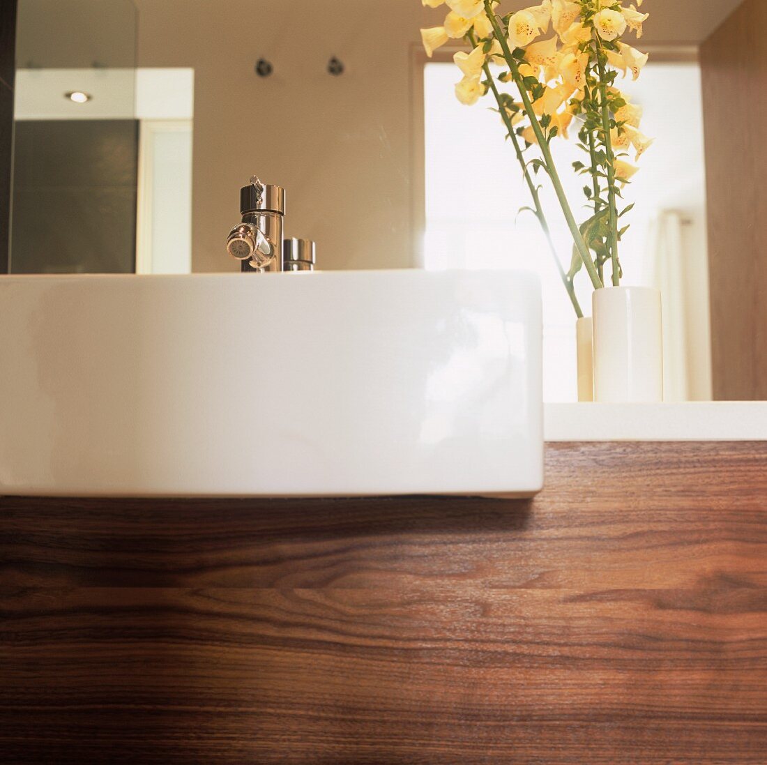 A modern white wash basin and walnut panelling