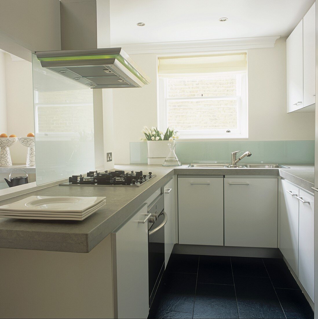 A functional white kitchen with an extractor fan above a work surface
