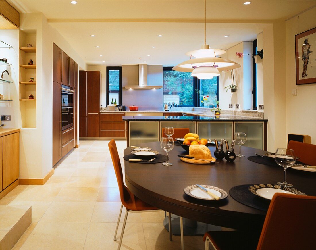 Gedeckter Esstisch mit Hängelampe aus Bauhauszeit in offener moderner Küche