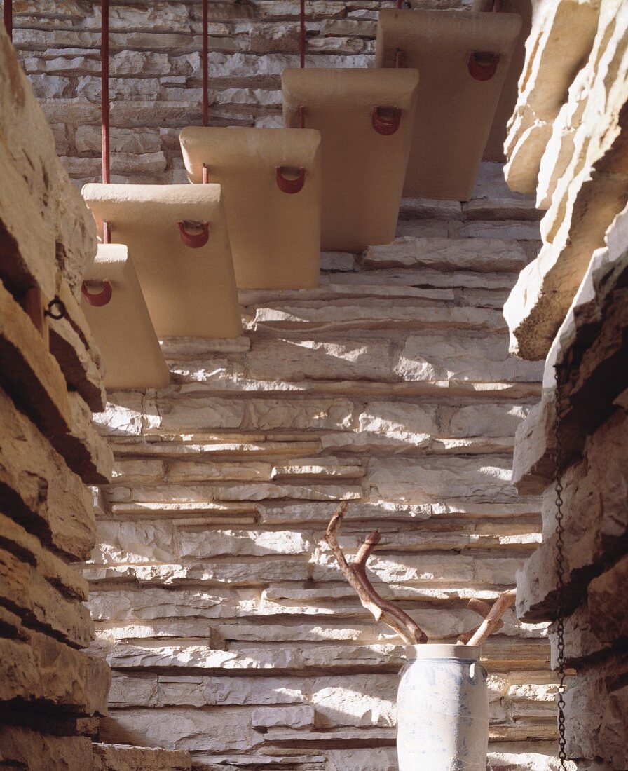 Auskragende Treppenstufen vor rustikaler Natursteinwand