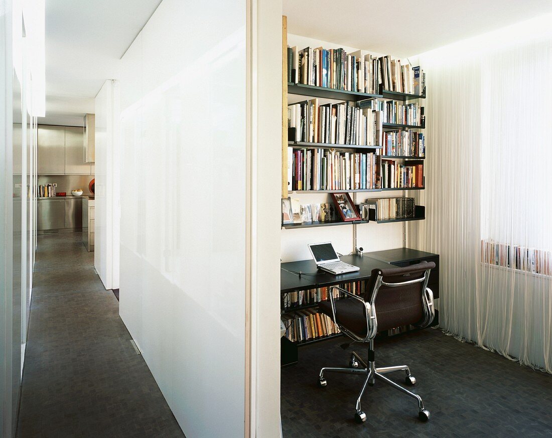 Blick vom langen Gang in kleine Schreibtisch-Ecke mit Wandborden und Schnurgardine