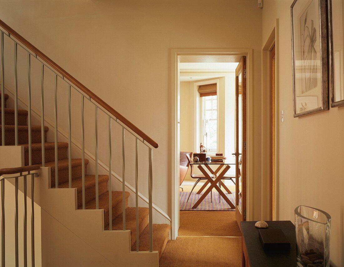 Wall-to-wall sisal carpeting in hall with staircase and adjacent dining room