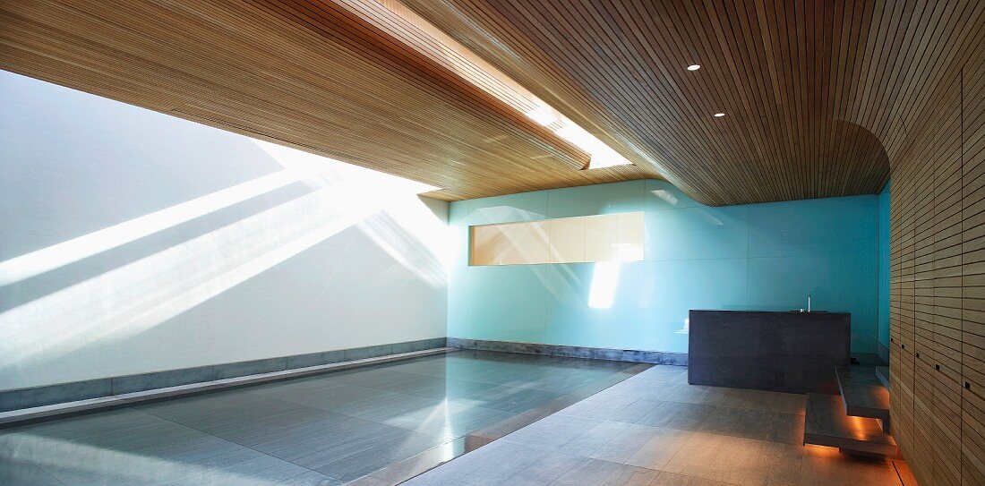 Moderne Holzverkleidung im Pool eines zeitgenössischen Hauses mit dramatischem Licht- und Schattenspiel auf Wand