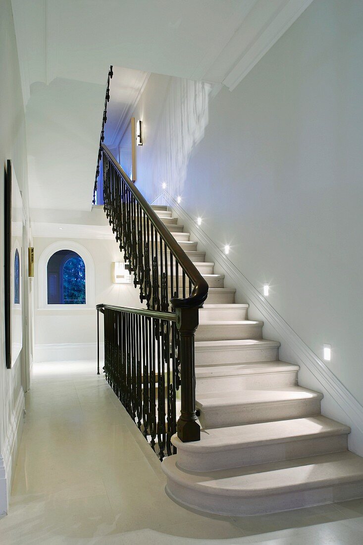 Traditional stairwell with stone stairs and black wrought iron balustrade