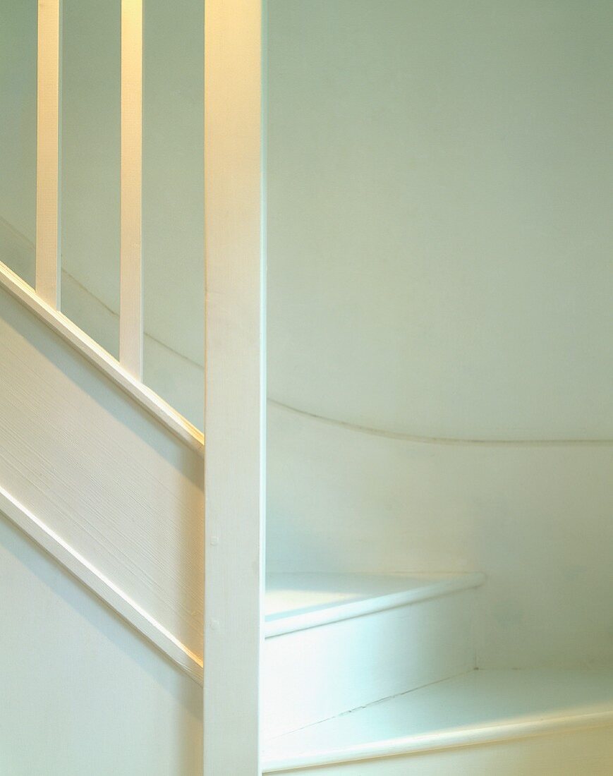 White stairwell, wooden stairs and balustrade