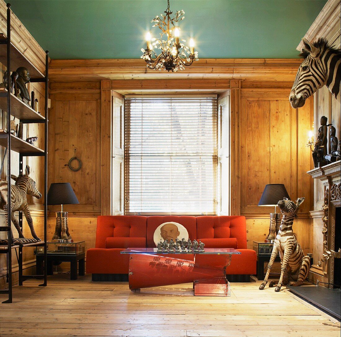Animal trophies in rustic modern salon with orange sofa in front of wooden wall