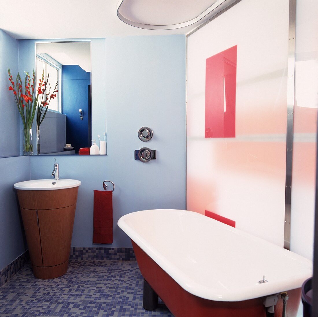 Bad mit modernem Waschtisch und Vintage Badewanne auf Mosaikfliesenboden