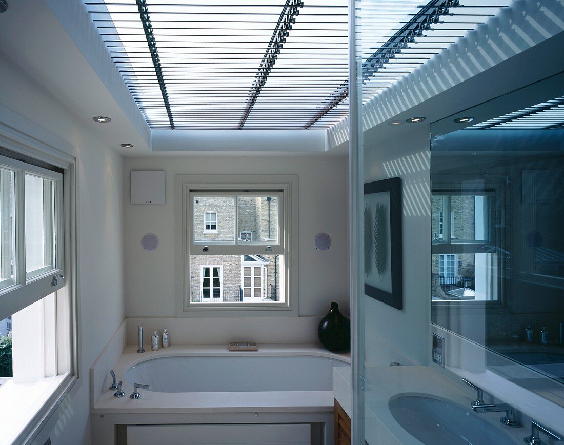 Licht-/Schatteneffekten durch horizontale Jalousie vor grossem Oberlicht in modernem Bad mit englischen Schiebefenstern