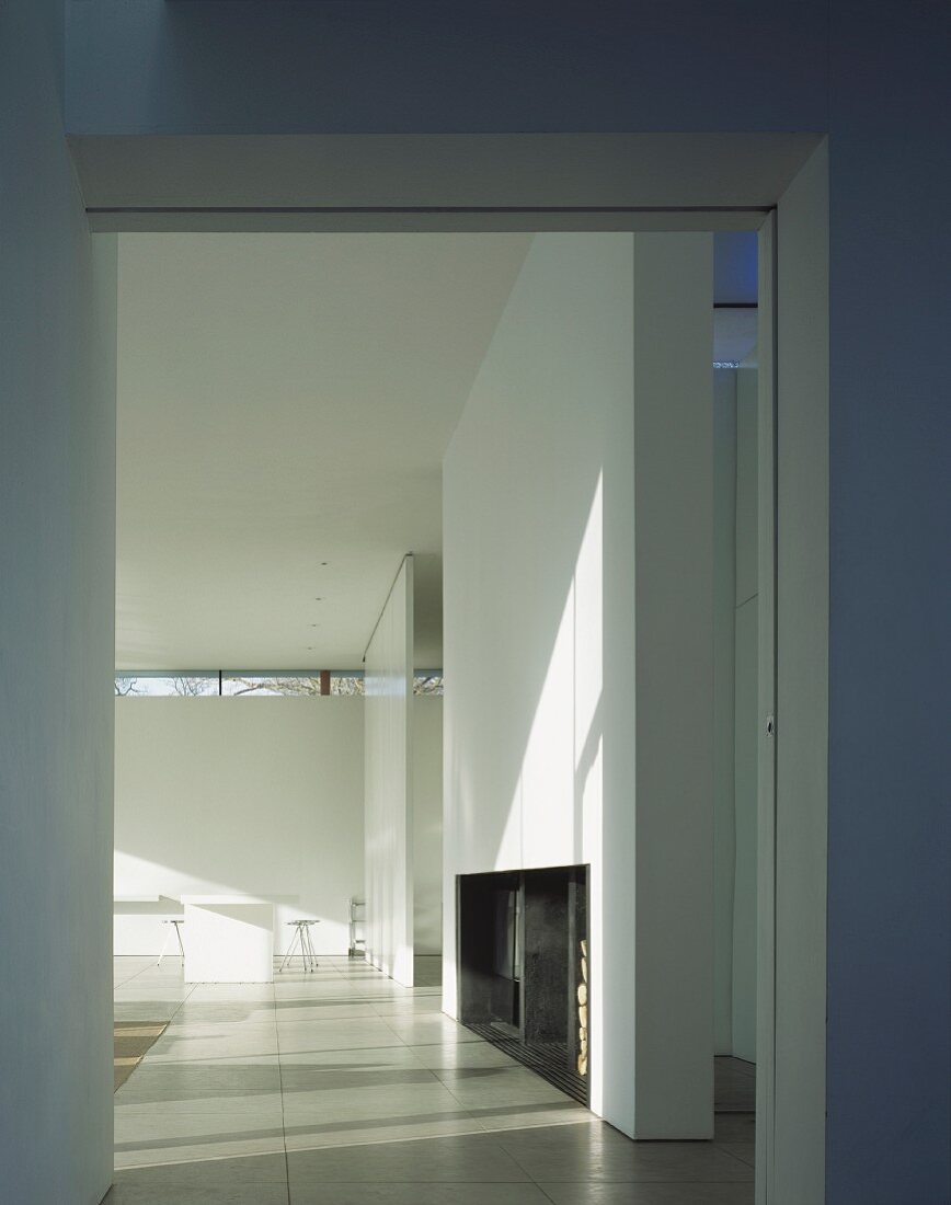 A view through a wide doorway into a minimalistic living room in a contemporary house