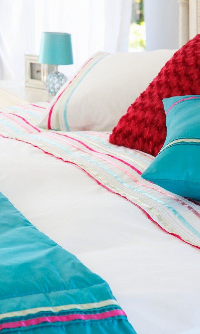 Verschiedenfarbige Kissen auf Bett