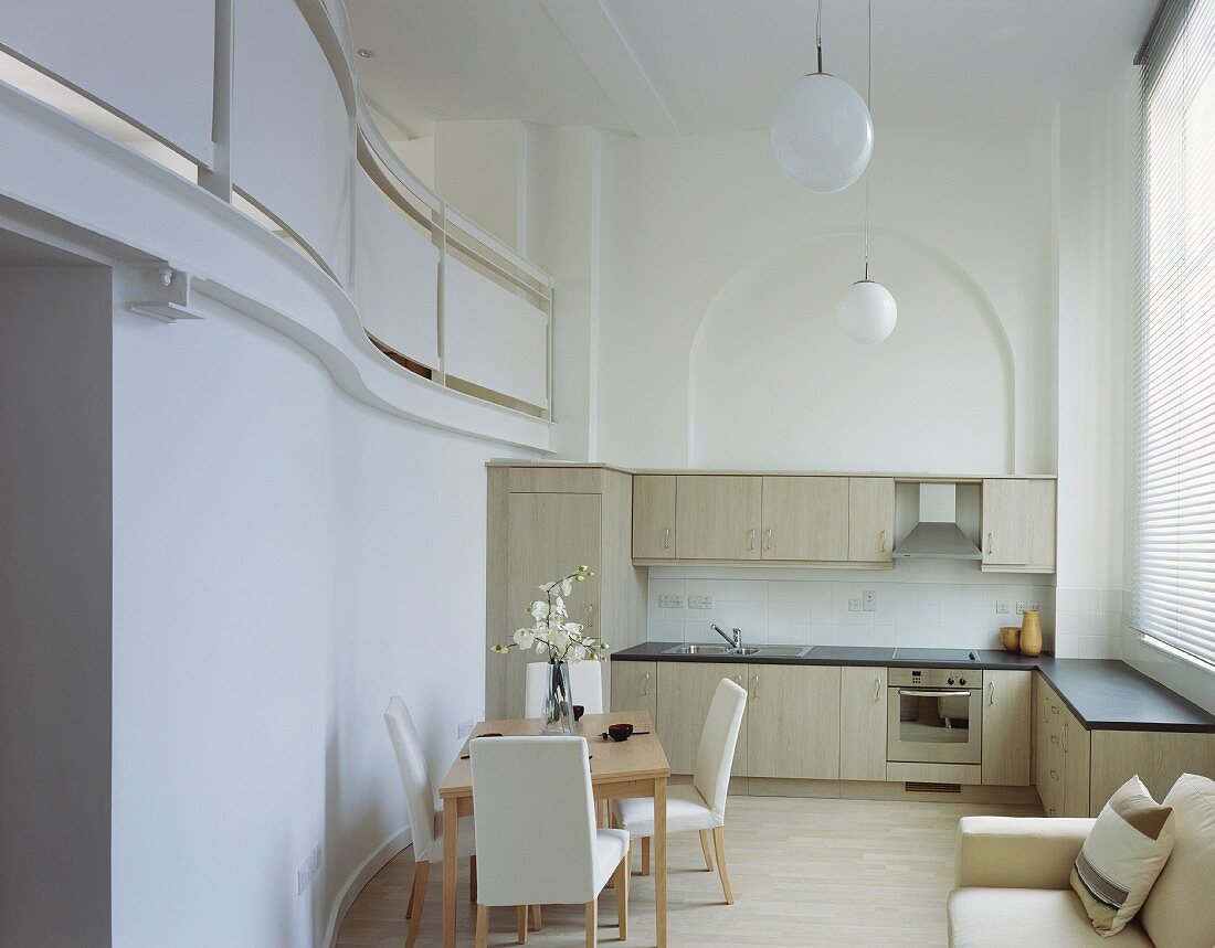 Essplatz in offener moderner Küche und Galerieblick in klassischem Ambiente