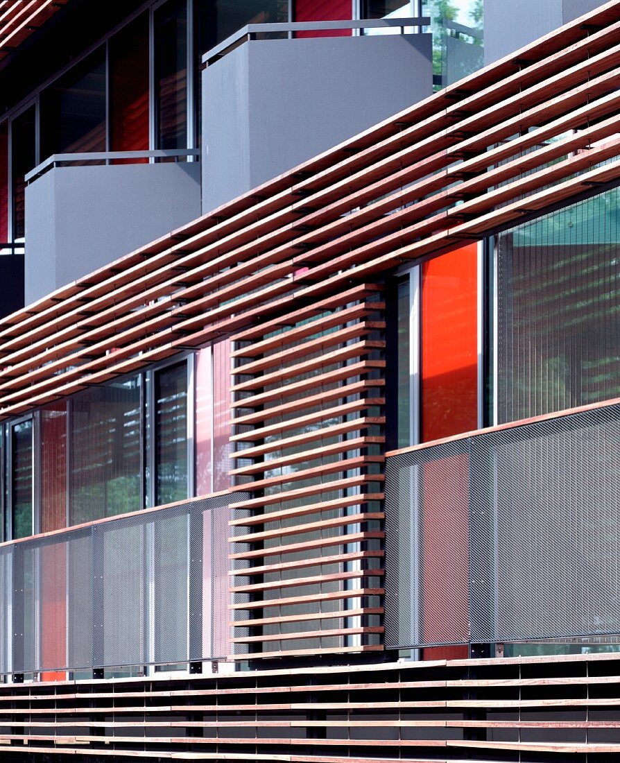Moderne Wohnhausfassade mit Balkon und horizontalen Holzlamellenverkleidung