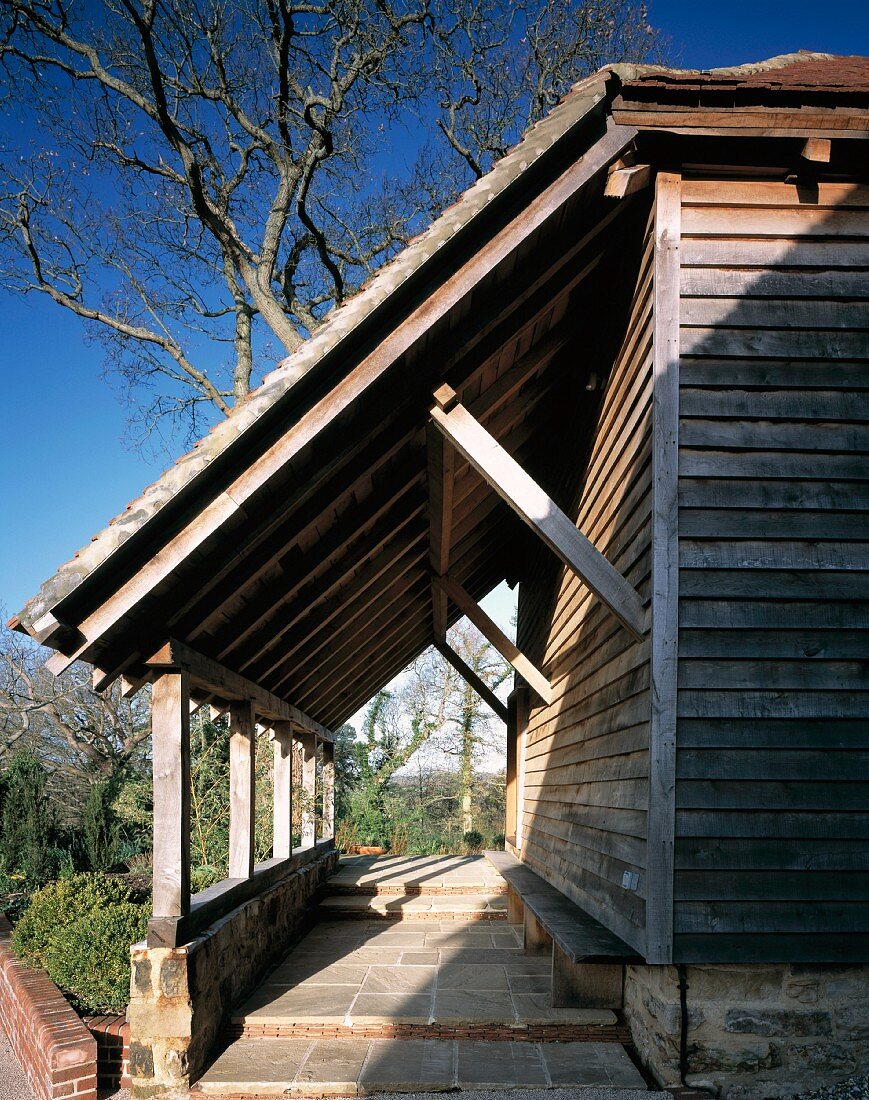 Holzhaus mit rustikalem Vordach über Eingangsbereich mit Stufen