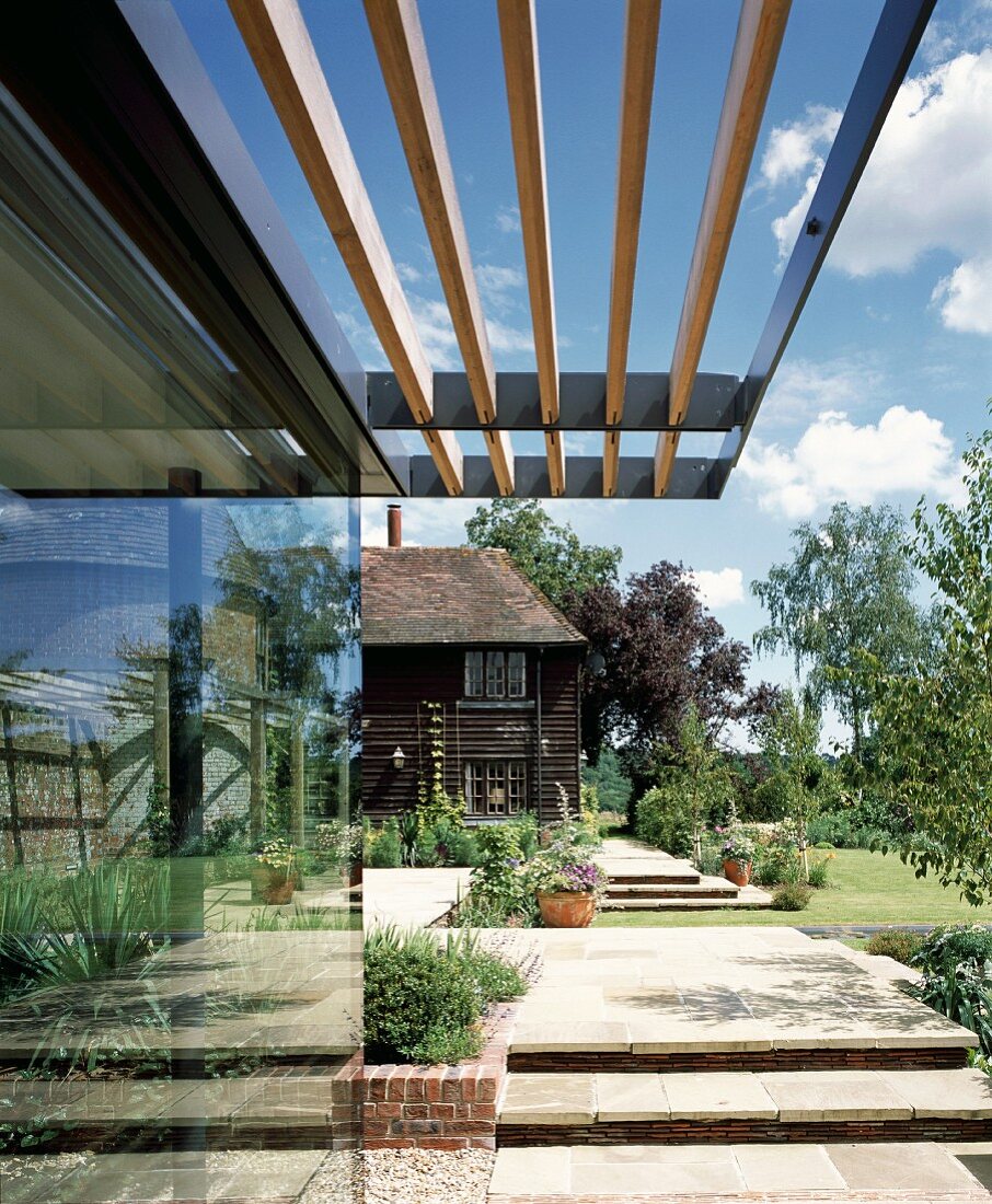 Sonnenschutzdach aus Holzlamellen an moderner Glasfassade