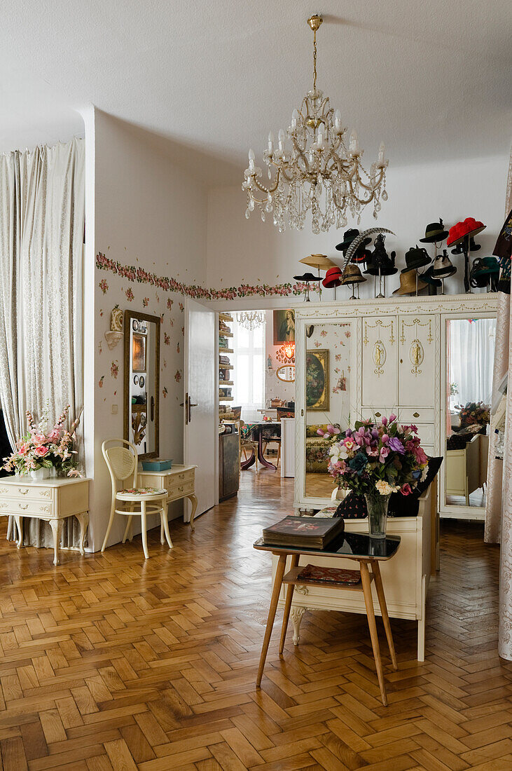 Living room with crystal chandelier, bouquets of flowers and herringbone parquet flooring