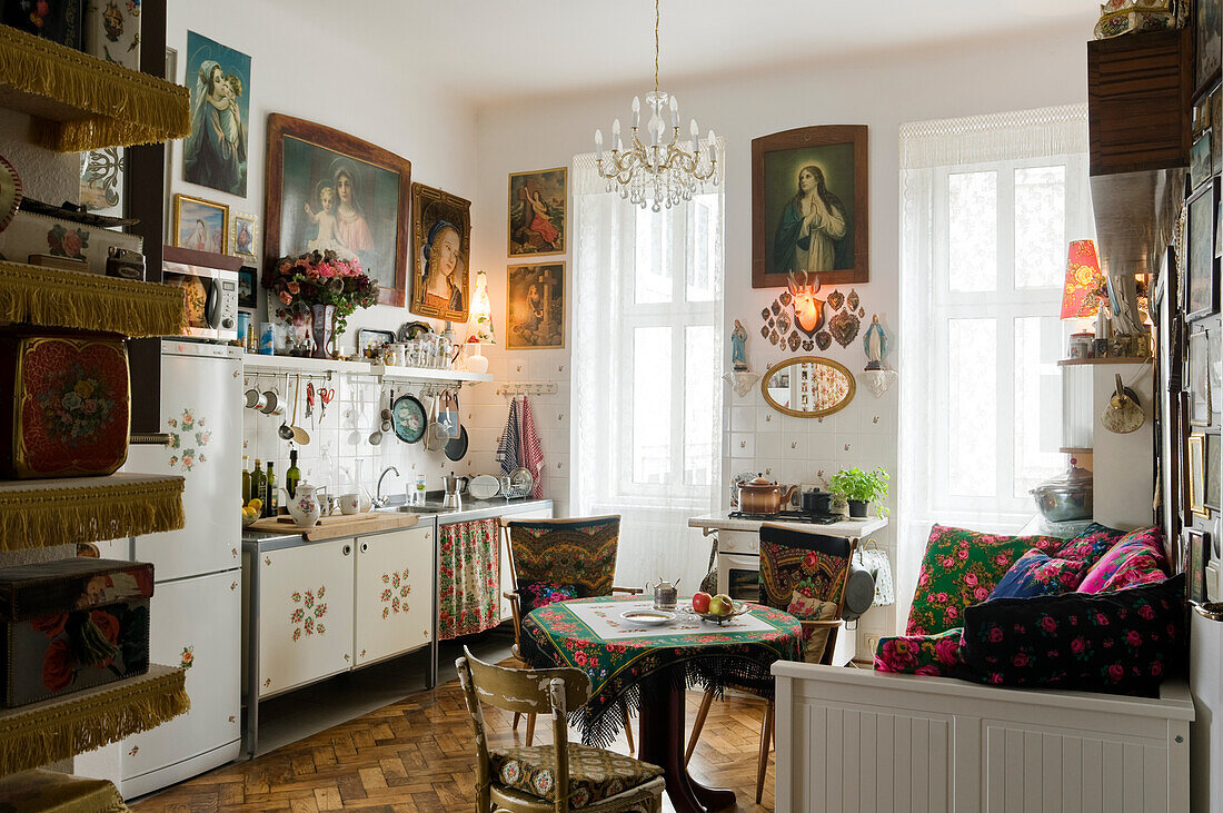 Vintage-Küche mit religiöser Wandkunst und bunt bestickten Textilien