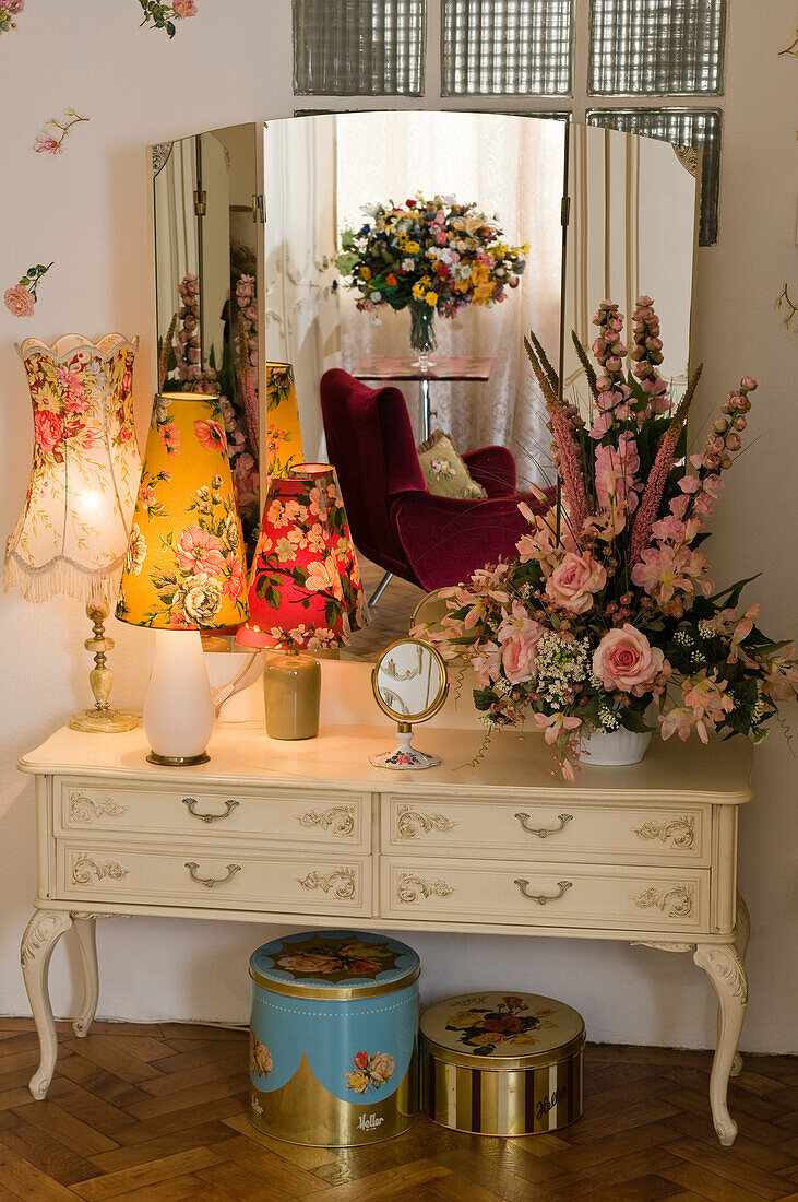 Vintage-Schminktisch mit Blumenarrangement und Tischlampen