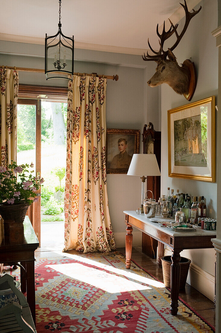 Traditional living room with hunting decor, antique carpet and bar corner