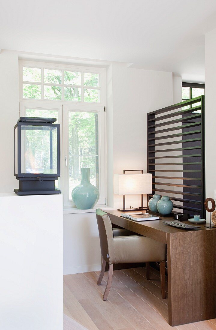 Minimalist wooden desk and retro upholstered chair in simple room