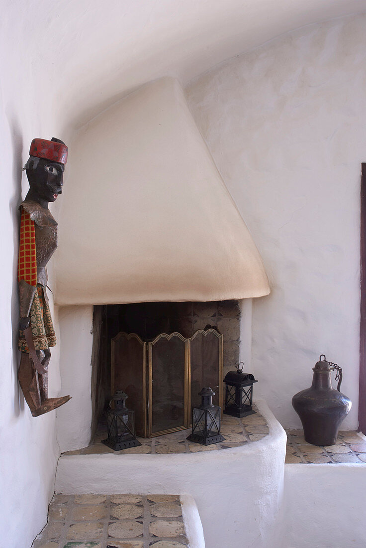 Masonry corner fireplace decorated with lanterns and sculpture on wall