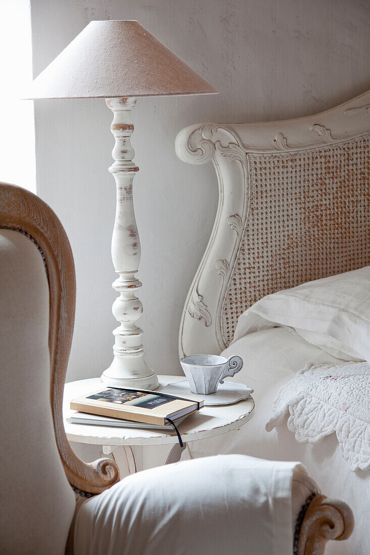 Bedside table with vintage-style table lamp next to a bed