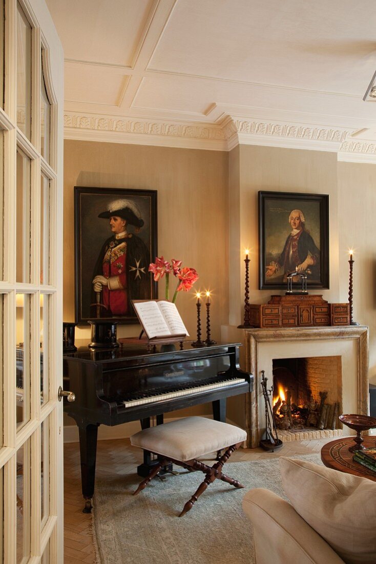 View though open door of grand piano next to fire in open fireplace