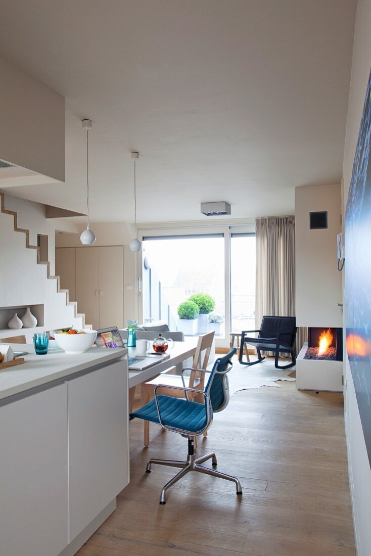 Küche mit Küchentheke im offenen, skandinavisch inspirierten Wohnraum mit Gaskamin