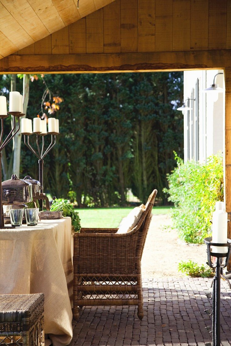 Set table with rustic candelabras and view into garden with edge of woodland