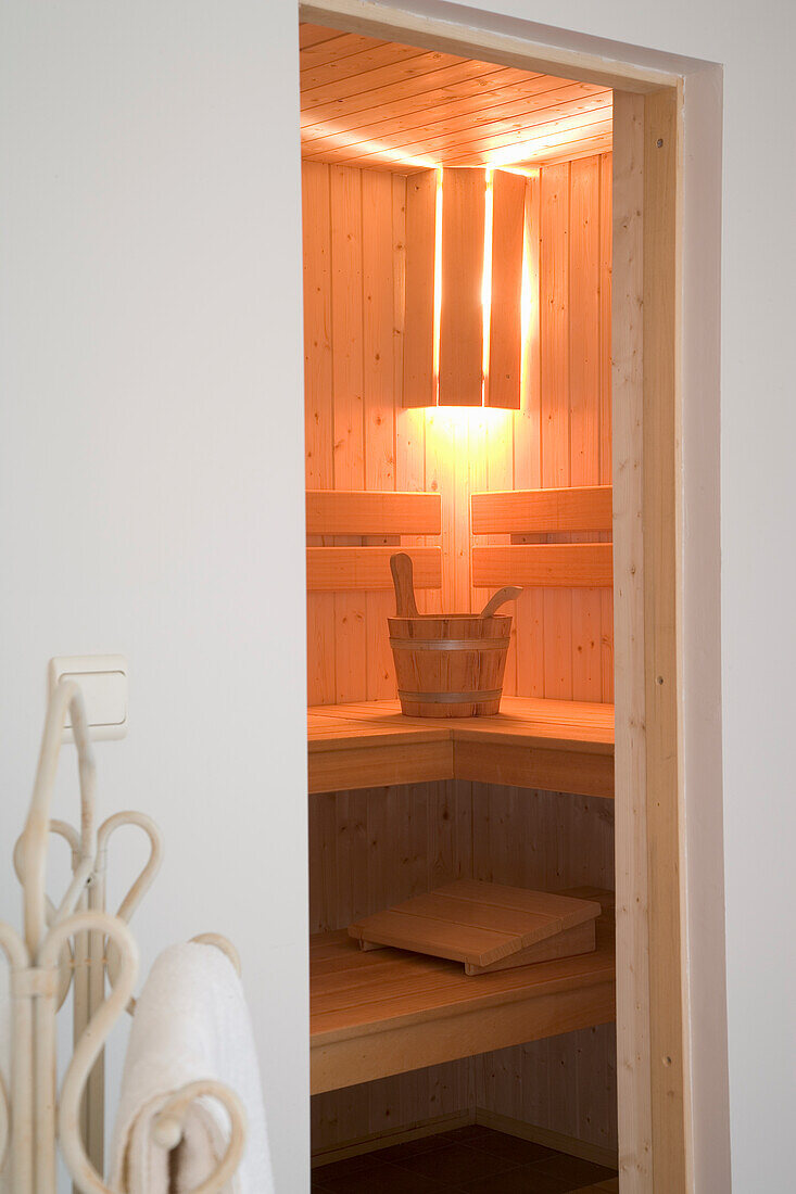 Wooden sauna with infusion bucket and integrated lighting