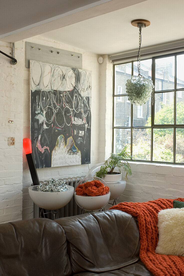 Living room with brown leather sofa and various works of art