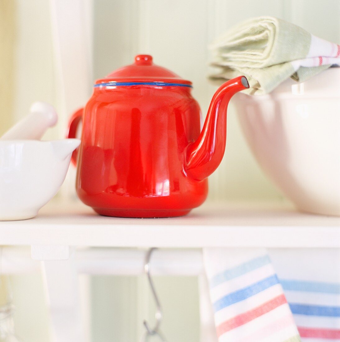 A teapot, a mortar and tea towels in a kitchen