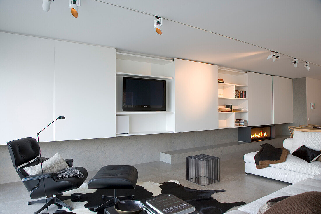 Minimalist living room with fitted wardrobes, modern fireplace and lounge chair