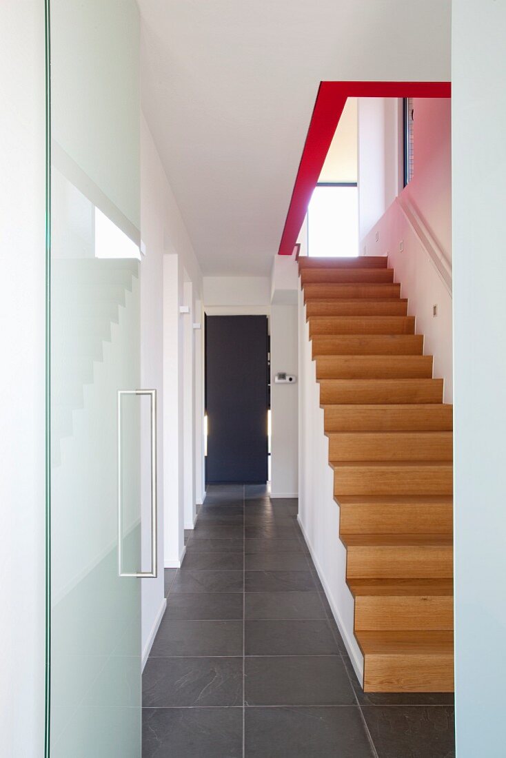Staircase in minimalist hall with stone floor