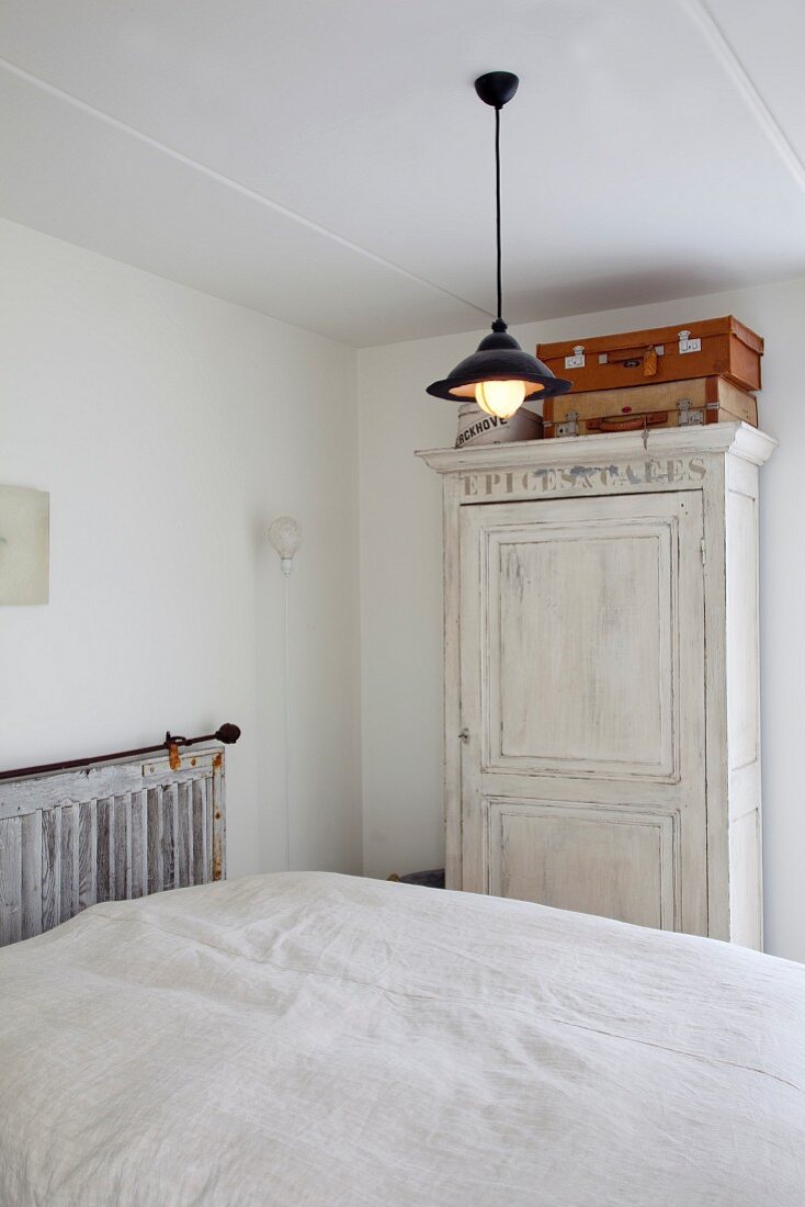 Simple bedroom with double bed and farmhouse wardrobe stained white
