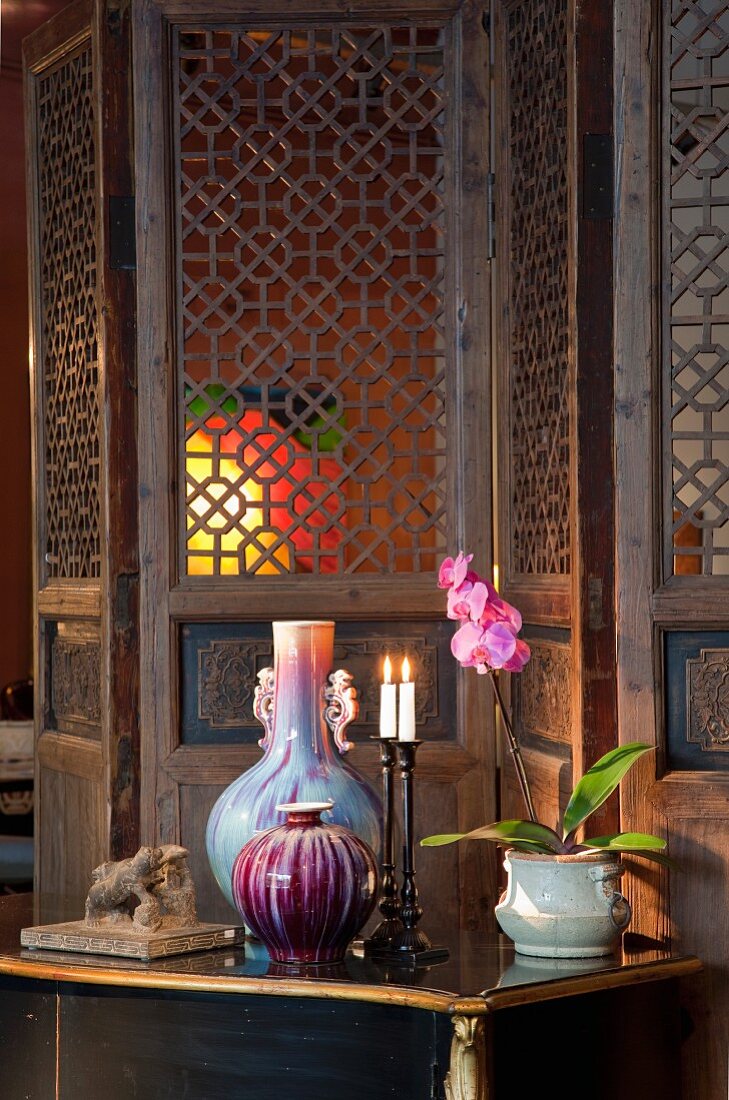 Ancient craftsmanship - valuable glass vases in front of wooden screen with ornately carved lattice