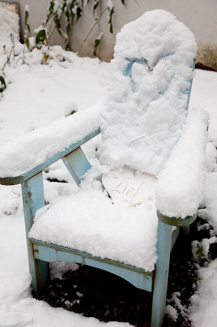 Snowy blue garden chair in winter