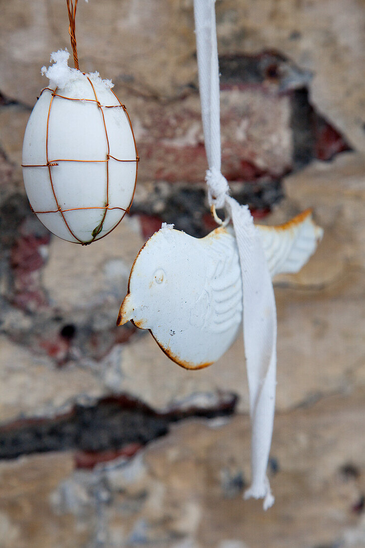 White metal Easter decoration on a rustic stone wall