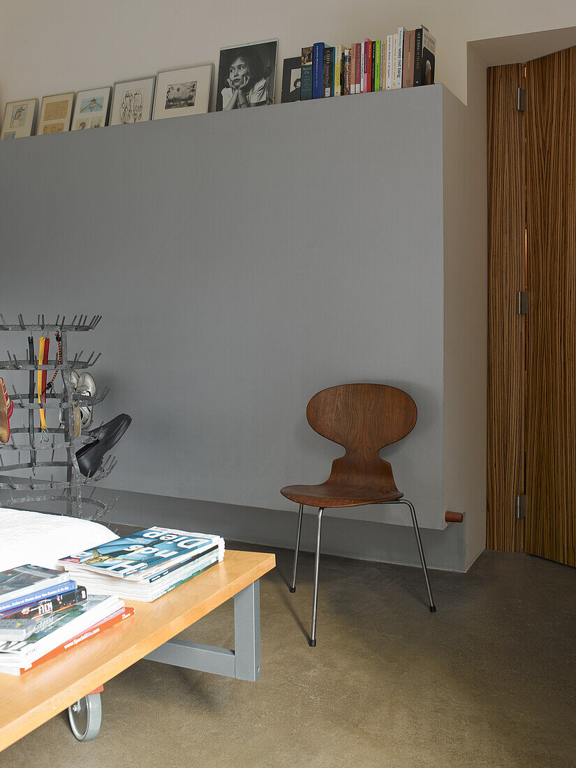 Room with grey wall, table, books and wooden chair