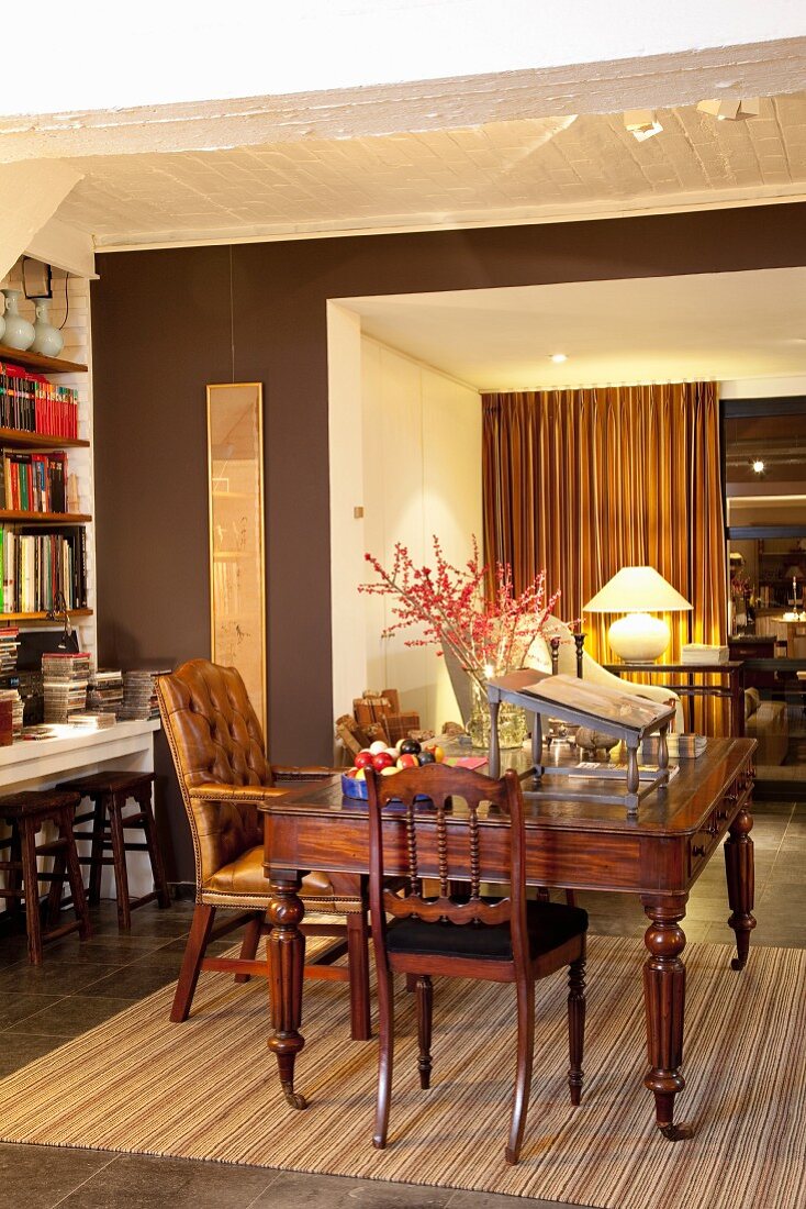 Traditional living-dining room in warm shades of brown with antique collectors' pieces