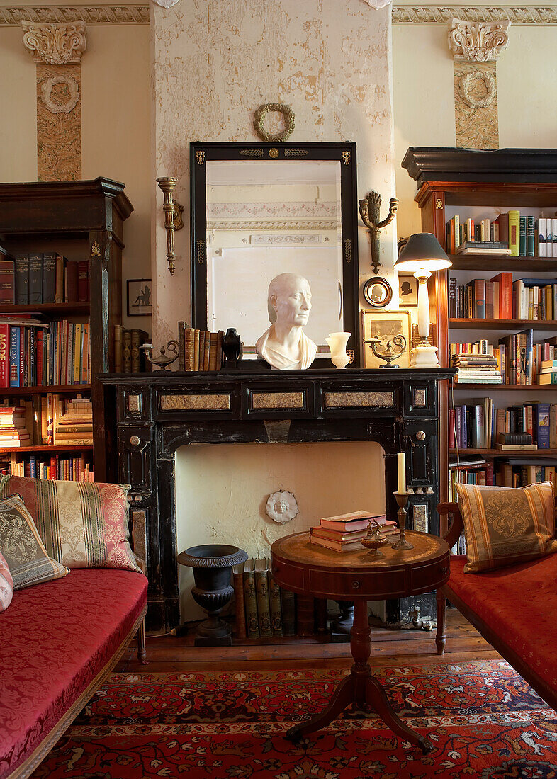 Classically furnished living room with bust, mirror and bookshelves