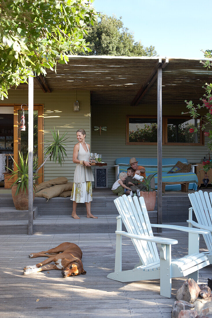 Relaxed summer atmosphere on wooden terrace with family and dog