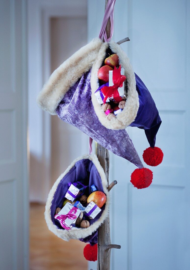 Nikolausmützen aus lila Samt mit Geschenken gefüllt