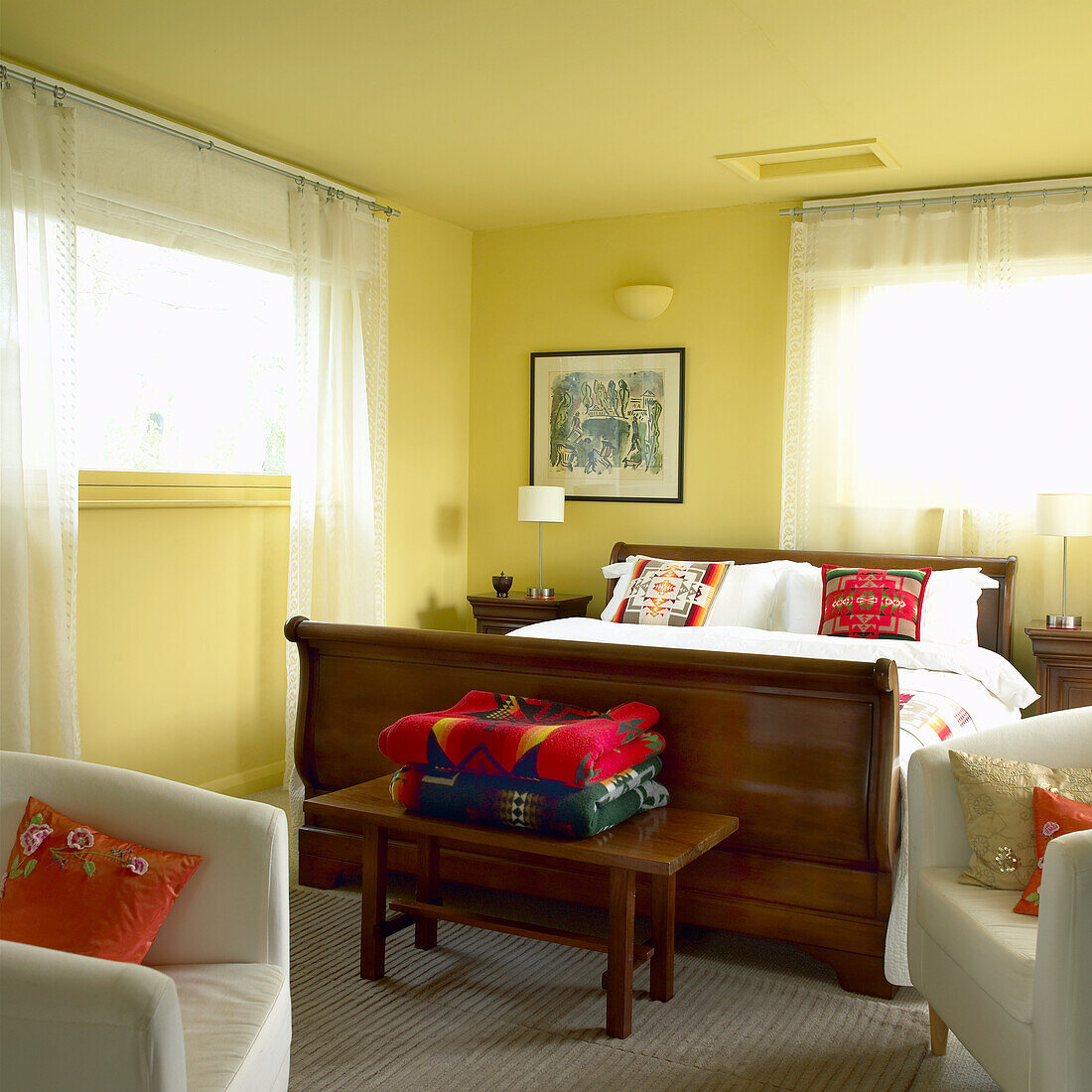 Schlafzimmer mit Holzbett und farbenfrohen Kissen