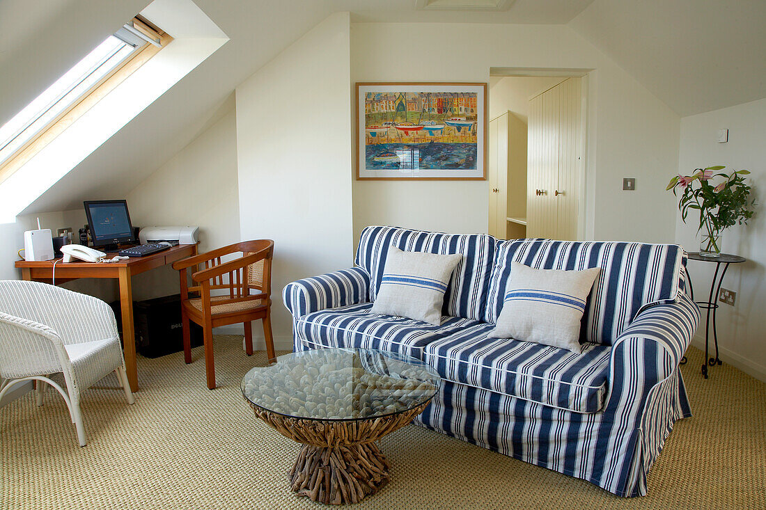 Living room on the top floor with striped sofa and workstation