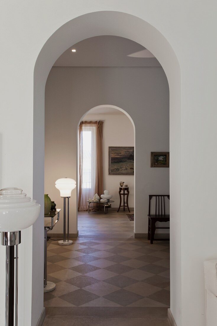 Zimmerflucht durch offene Rundbögen in traditionell eleganter Wohnung mit Antiquitäten